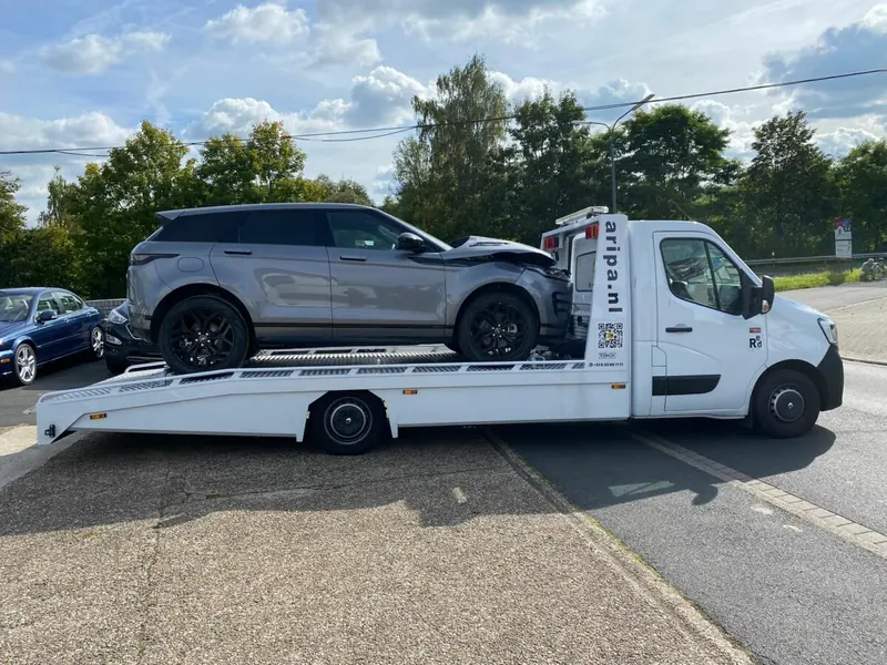 Beschadigde SUV wordt op de Aripa autotransporter vervoerd