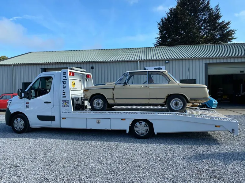 Oude BMW op het laadplatform van de Aripa autotransporter